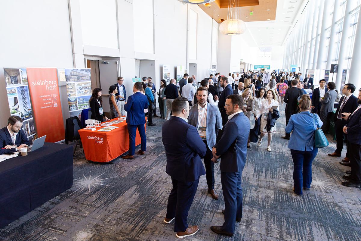 A busy exhibit concourse with booths on both sides